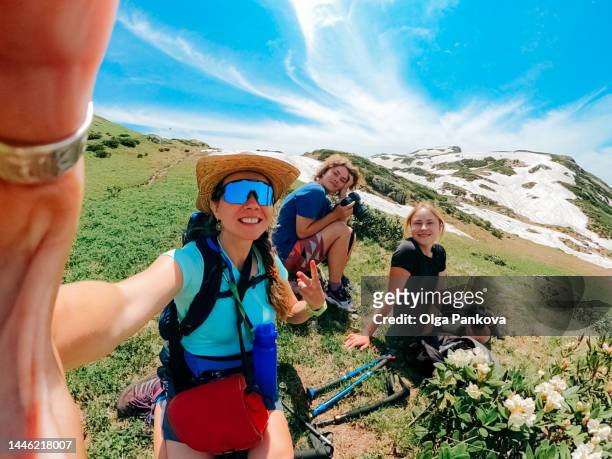 female friends hikers relax during a hike in the mountains and take selfie. - action camera stock pictures, royalty-free photos & images