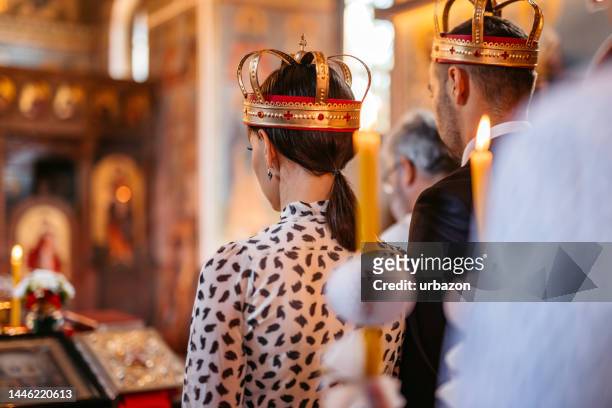 young couple wearing wedding crowns during church wedding ceremony - orthodox stock pictures, royalty-free photos & images