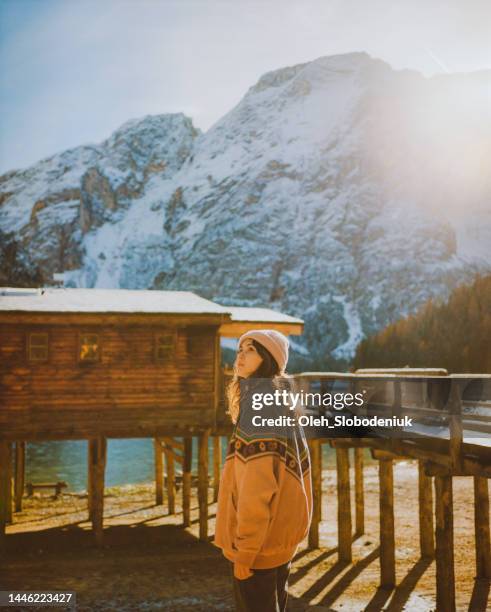woman walking near lago di braies wooden pier in winter - the shack filme imagens e fotografias de stock