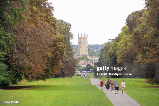 tourists and local people taking a walk in the beautiful cirencester park, in cirencester, the cotswolds gloucestershire, england on a late summers day - cirencester stock pictures, royalty-free photos & images
