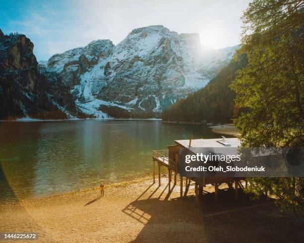 woman walking near lago di braies wooden pier in winter - the shack filme imagens e fotografias de stock