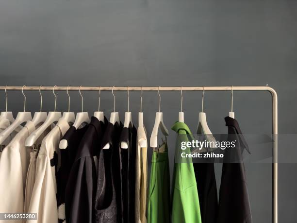 row of clothes on hangers - clothes rack stock-fotos und bilder