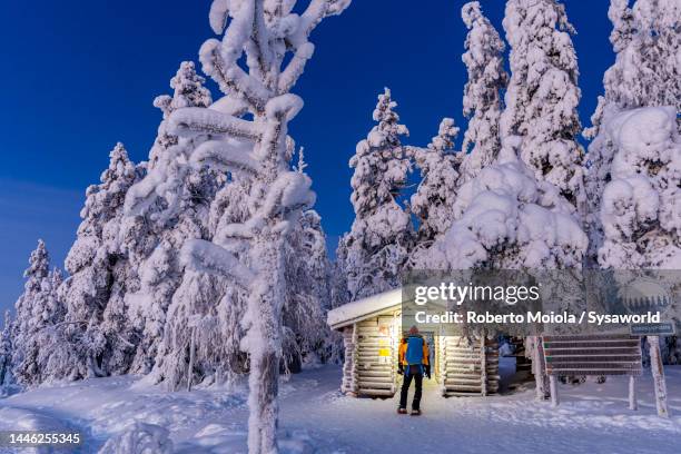 man with snowshoes admiring a snowy mountain hut - rime ice stock pictures, royalty-free photos & images