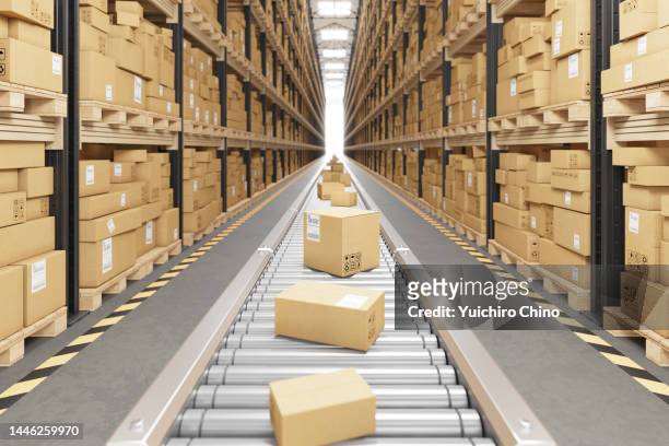 cardboard boxes on conveyor belt in warehouse - contenitore foto e immagini stock