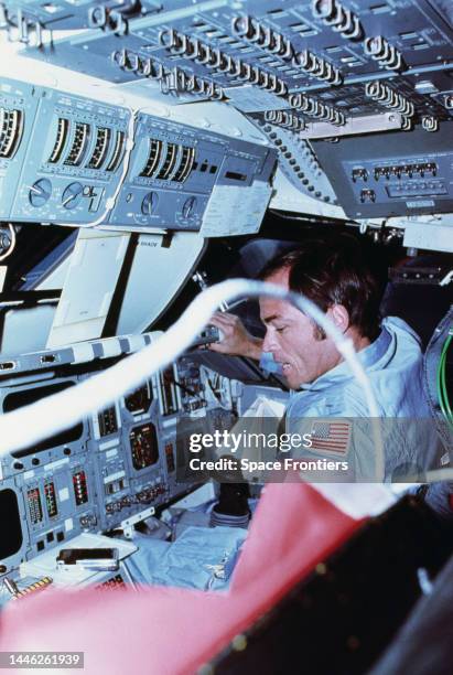 American astronaut John Young sitting at the commander's station on the port side of the forward flight deck of the Space Shuttle Columbia during...