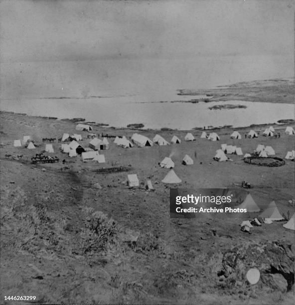 Tule Lake beyond the tents and horses of a military camp during the Modoc War in Siskiyou County, California, circa 1873. The Modoc War was fought...