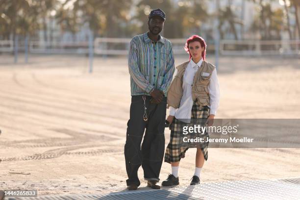 Guest seen wearing a cap and a striped shirt, oversized pants and boots and another guest seen wearing a white oversized blouse, a patterned long...