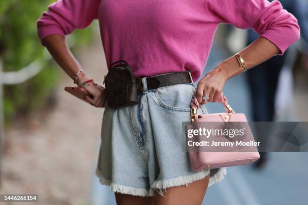 Guest seen wearing a pink Louis Vuitton capucines mini bag, denim shorts and a pink longsleeve, a mini belt, Cartier love bracelet and a Cartier just...