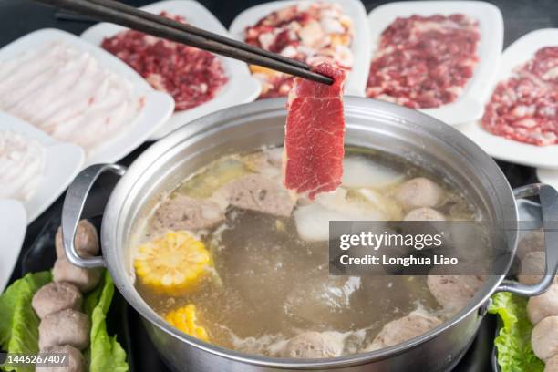 chopsticks take the beef slices from the hot pot - hot pots stock pictures, royalty-free photos & images