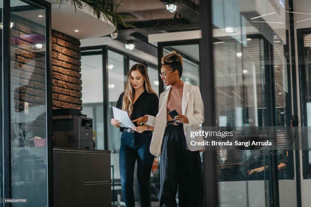 Young female employees walking down the company corridor