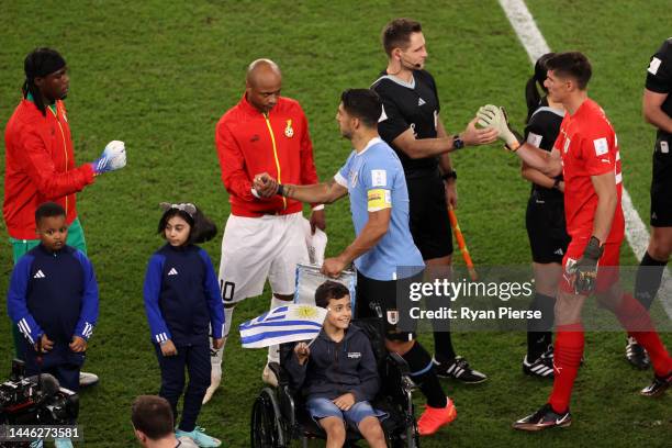 Luis Suarez of Uruguay shakes hands with Andre Ayew of Ghana prior to the FIFA World Cup Qatar 2022 Group H match between Ghana and Uruguay at Al...