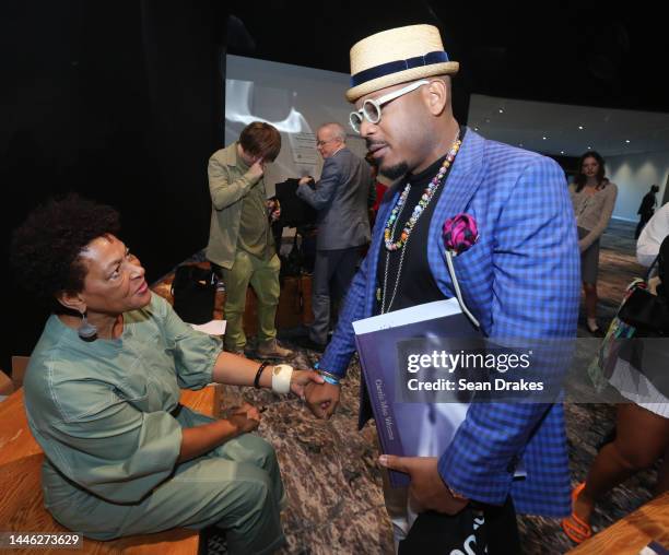 Celebrated artist Carrie Mae Weems greets jazz recording artist Etienne Charles during her book signing after an Art Basel Conversations panel during...