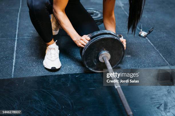 woman preparing a lift bar bell in gym - gewichtheffen voor vrouwen stockfoto's en -beelden