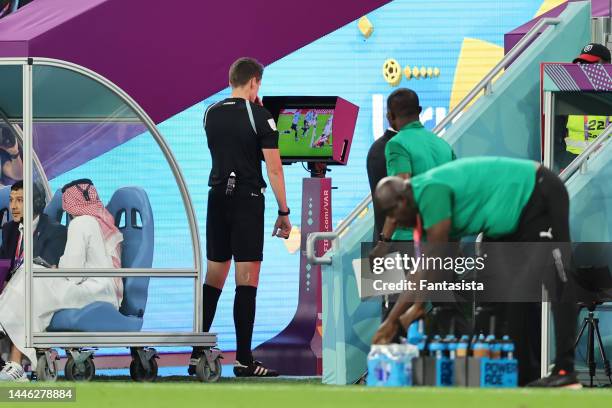 The Referee Daniel Siebert of Germany checks the VAR monitor prior to awarding Ghana a first half penalty during the FIFA World Cup Qatar 2022 Group...