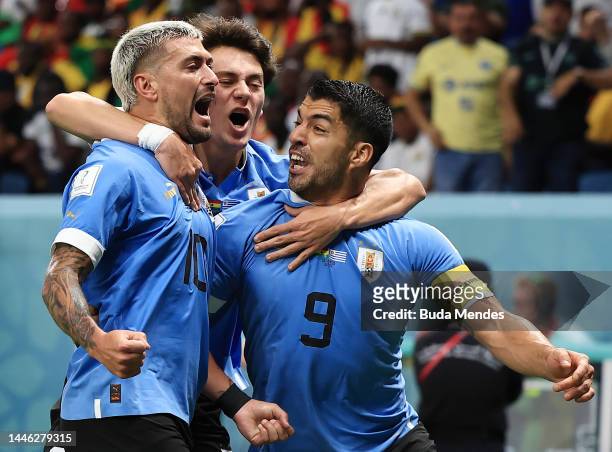 Giorgian de Arrascaeta of Uruguay celebrates after scoring the team's first goal with teammates Facundo Pellistri and Luis Suarez during the FIFA...
