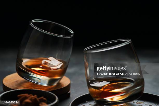 the glass of whisky on the table with dark background - cognac glass stock pictures, royalty-free photos & images