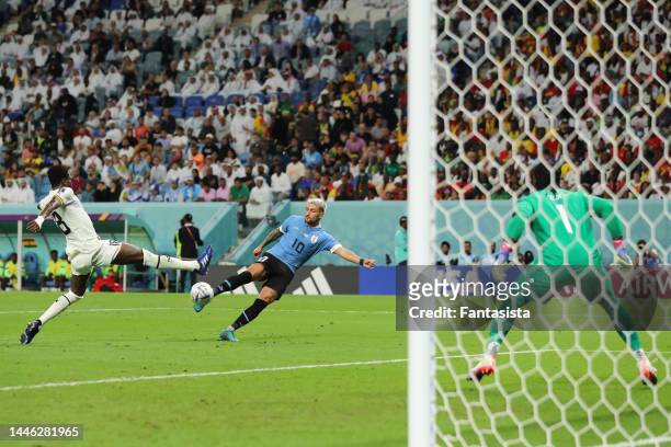 Giorgian de Arrascaeta of Uruguay fires the ball past Lawrence Ati-Zigi of Ghana to give the side a 2-0 lead during the FIFA World Cup Qatar 2022...
