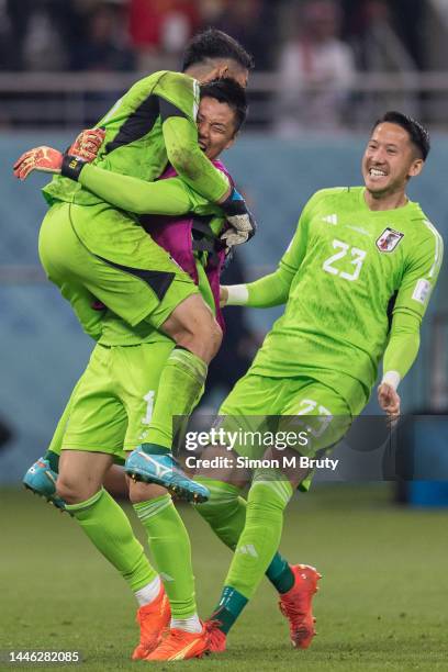 Japan goalkeeper Shuichi Gonda celebrates with substitute goalkeepers Eiji Kawashima and Daniel Schmidt at full-time during the FIFA World Cup Qatar...