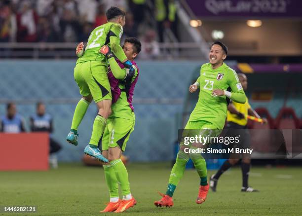 Japan goalkeeper Shuichi Gonda celebrates with substitute goalkeepers Eiji Kawashima and Daniel Schmidt at full-time during the FIFA World Cup Qatar...