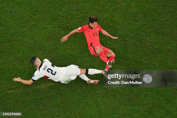 Heechan Hwang of Korea Republic is challenged by Diogo Dalot of Portugal during the FIFA World Cup Qatar 2022 Group H match between Korea Republic...