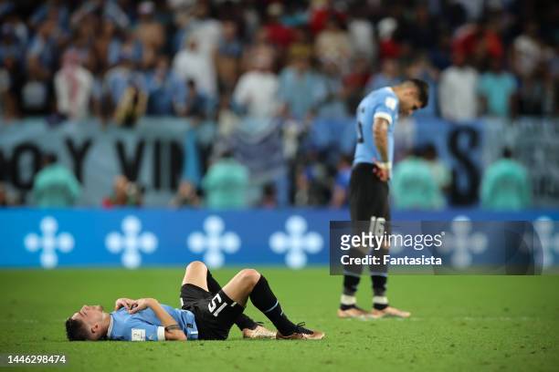 Federico Valverde and Mathias Olivera of Uruguay react following the team's elimination at the final whistle of the FIFA World Cup Qatar 2022 Group H...