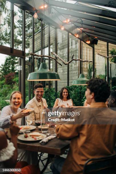 cheerful multiracial business colleagues having dinner in dining room - dinner friends stock-fotos und bilder