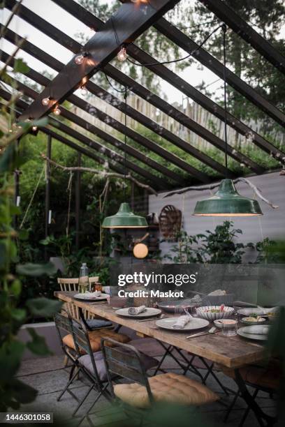 food arranged on table in dinner party during sunset - サンルーム ストックフォトと画像