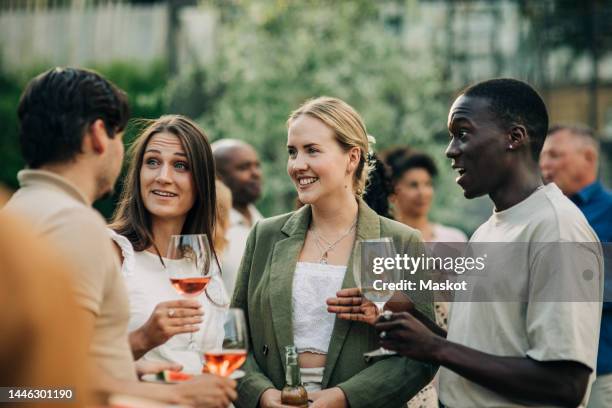 multiracial female and male friends having drinks together in social event during sunset - young professional at party stock-fotos und bilder