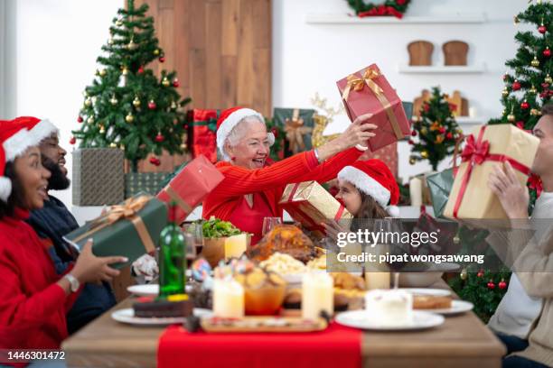 the family is happily exchanging gifts at christmas. - exchanging stock pictures, royalty-free photos & images