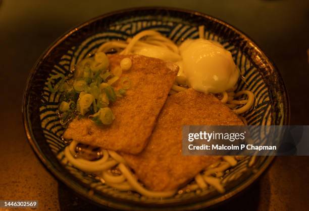 kitsune udon - noodle bowl with fried tofu, poached egg and spring onions. - bowl of ramen stock pictures, royalty-free photos & images