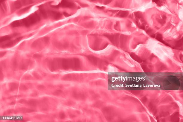 closeup of clear water surface texture with splashes and bubbles. trendy abstract nature background. ripple water texture on pink background. demonstration of color of the year 2023. color of the year. viva magenta. - collagens stock pictures, royalty-free photos & images