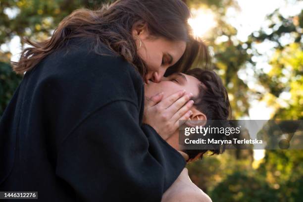 beautiful young couple outdoors in the park. portraits of lovers. autumn. spring. holiday valentine's day. - couple kissing stock pictures, royalty-free photos & images