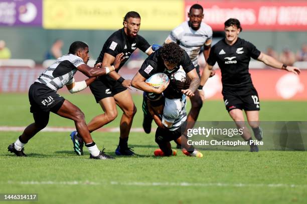 Che Clark of New Zealand is tackled during the match between Fiji and New Zealand on day one of the HSBC World Rugby Sevens Series - Dubai at The...