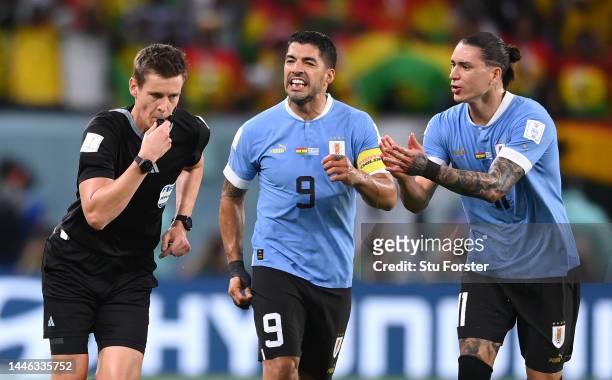 Luis Suarez and Darwin Nunez of Uruguay protest to Referee Daniel Siebert after awarding a penalty to Ghana after the video assistant referee review...