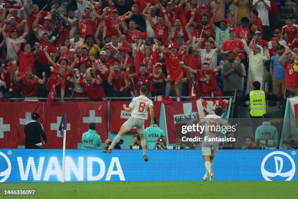 Remo Freuler of Switzerland celebrates with team mate Ricardo Rodriguez after scoring to give the side a 3-2 lead during the FIFA World Cup Qatar...