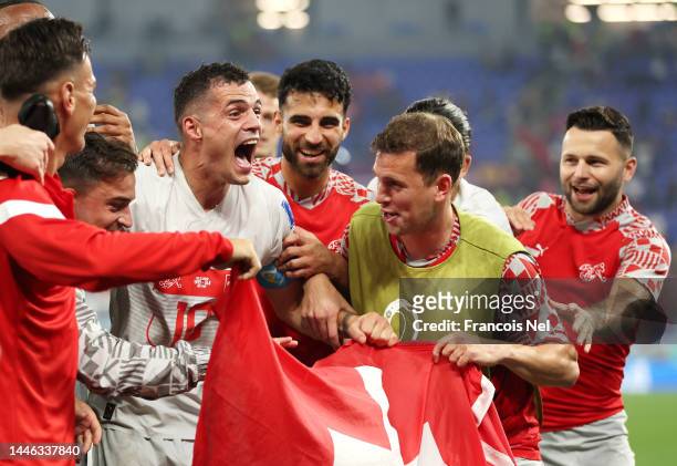 Switzerland players celebrate their 3-2 victory and qualification for the knockout stage after the FIFA World Cup Qatar 2022 Group G match between...