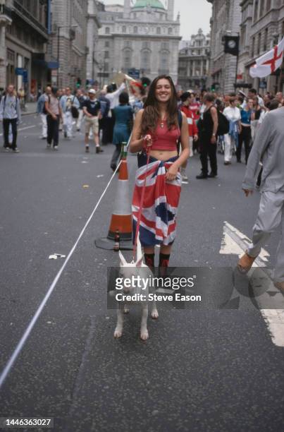Marcher with a union jack skirt and a bull terrier on a lead at the Lesbian, Gay, Bisexual, and Transgender Pride event, Regent Street St James,...