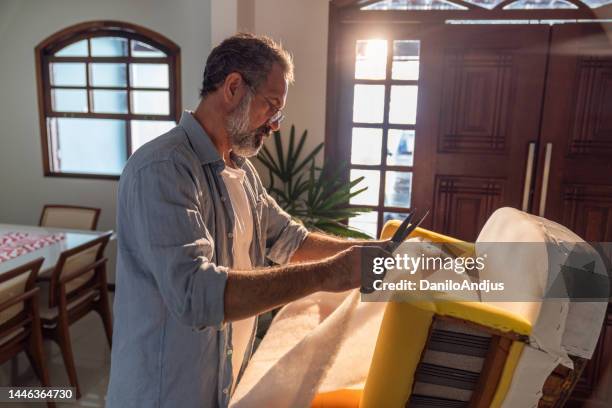 an expert upholsterer working on his new armchair - upholstry stockfoto's en -beelden