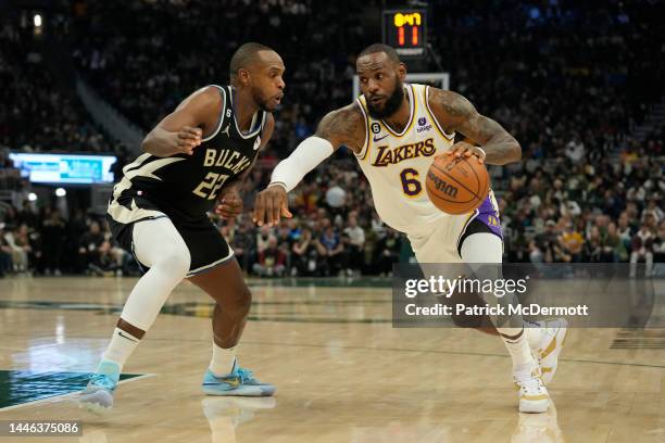 LeBron James of the Los Angeles Lakers dribbles the ball against Khris Middleton of the Milwaukee Bucks during the first half of the game at Fiserv...