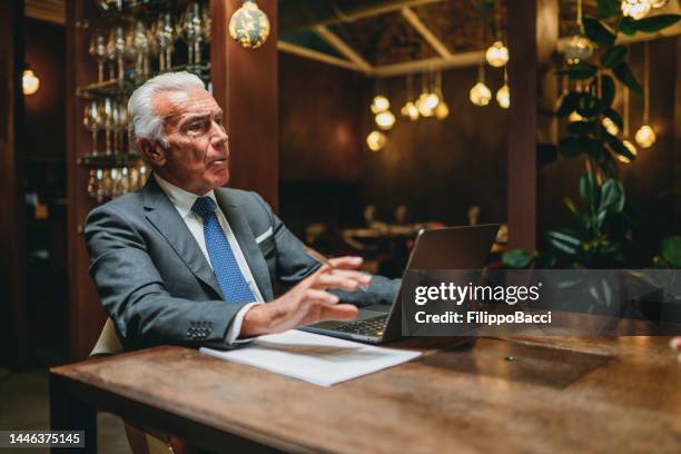 a man is talking with colleagues in a restaurant - the nomad hotel stock pictures, royalty-free photos & images