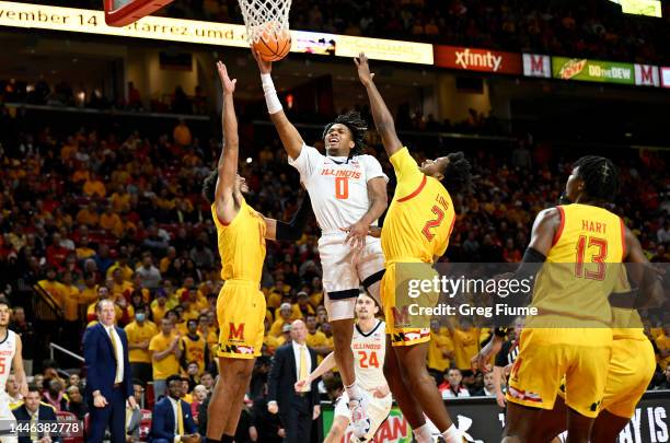 Terrence Shannon Jr. #0 of the Illinois Fighting Illini drives to the hoop in the first half against Patrick Emilien and Jahari Long of the Maryland...