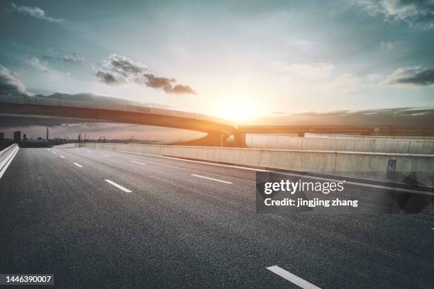 viaduct highway leading to the city in the evening, after the sun has set - new pavement stock pictures, royalty-free photos & images