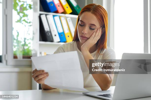 sadness woman reading letter - law problems stock pictures, royalty-free photos & images