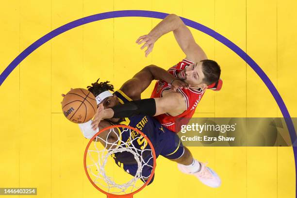 Kevon Looney of the Golden State Warriors and Nikola Vucevic of the Chicago Bulls go for a rebound at Chase Center on December 02, 2022 in San...