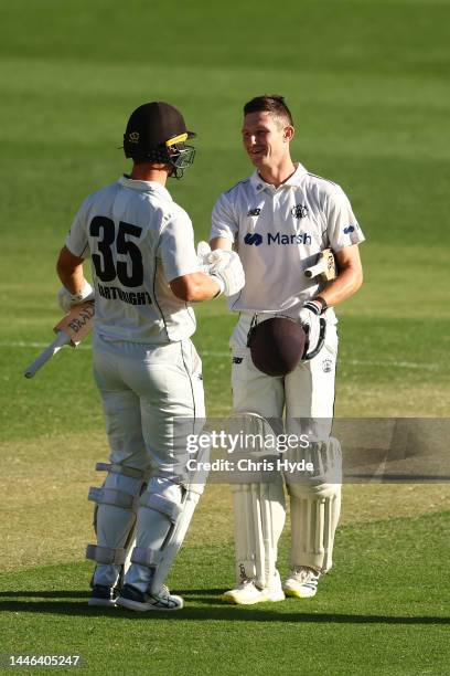 Cameron Bancroft of Western Australia celebrates his century with team mate Hilton Cartwright during the Sheffield Shield match between Queensland...