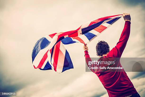 man waving union jack flag - england flag stock-fotos und bilder