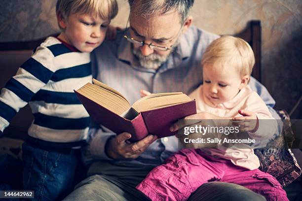 grandfather with his grandchildren - child reading book stock pictures, royalty-free photos & images