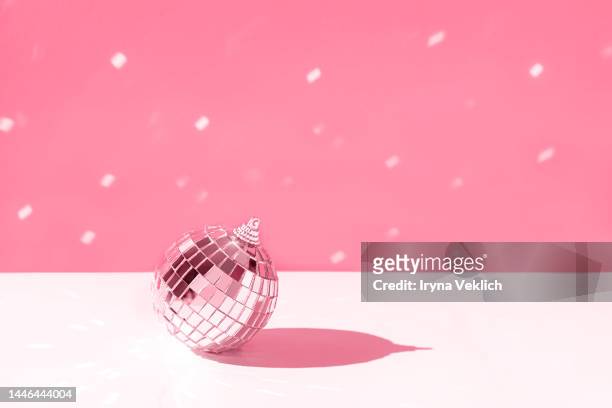 merry christmas and happy new year invitation. silver disco ball on  pastel red viva magenta color of the year 2023 background with snow. - silver disco ball stock pictures, royalty-free photos & images
