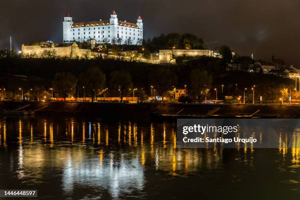 bratislava cityscape reflected on the danube river at night - slovakia monuments stock pictures, royalty-free photos & images