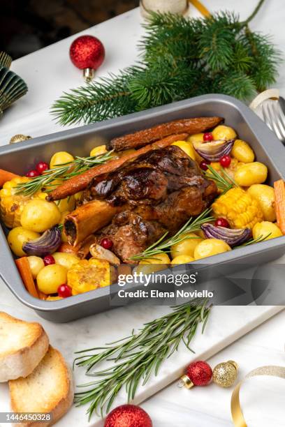 holiday dinner food pork shank with baked potatoes and corn, festive food with christmas new year decor - christmas leg ham stock-fotos und bilder